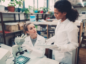 two women in labcoats discussing, gender in stem