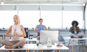 Executives doing yoga in office How to create a supportive working environment for your employees’ mental health